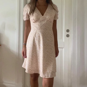 Blommig klänning  - En supersöt blommig klänning från Chiquelle i storlek xs. Den är gul/beige med vita blommor. Endast använd en gång. 