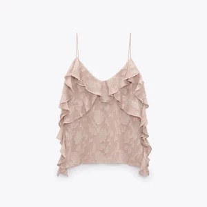 Beige volangtop med blommönster - Supersöt rosa linnetopp med tunna axelband och volanger längs v-ringningen och sidorna. Tunt, lätt tyg med diskret blommigt mönster som ger en somrig vibe. Perfekt för varma dagar när du vill känna dig extra fin.