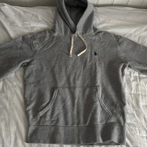 Grå hoodie från Polo Ralph Lauren - Tja! Säljs pågrund av att jag har växt ur den. Jättebra skick och sparsamt använd.  Hoodien är nästan ny, köptes i februari och kostar ca 2200kr nypris och köptes på Zalando. Pris går att diskuteras, skriv vad du vill ge så får vi se! Inga defekter finns! Hör av vid minsta lilla fråga! Kan gå ner till 1250kr