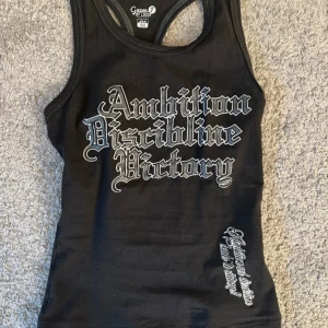 Svart linne med y2k print - Svart linne från Gazoz med coolt tryck i gotisk stil på både fram- och baksidan. Perfekt för dig som gillar streetwear och 2000s emo/gotisk design. Passar xs-s