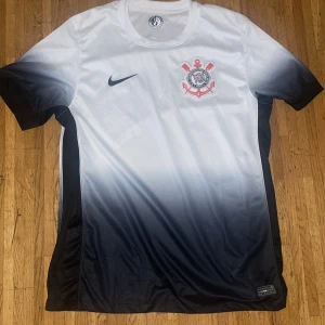 Corinthians Nike fotbollströja svart/vit - Snygg Corinthians fotbollströja från Nike i Dri-FIT-material. Perfekt för dig som vill sticka ut på planen eller på läktaren. Köpt i Brasilien använt typ två gånger. Pris kan diskuteras.
