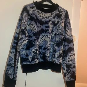 Mönstrad blå och svart stickad tröja - Säljer en stickad tröja i storlek M ifrån Carin Wester med mönster i blått, svart och vitt. Tröjan har rund halsringning, långa ärmar och ribbade muddar vid ärmslut och nederkant. Perfekt för dig som gillar statement-plagg och coola detaljer. Pris kan diskuteras🥰