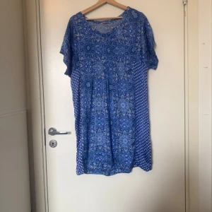 Blå mönstrad klänning Odd Molly - Supersöt blå kortklänning med vackert blommigt och geometriskt mönster. Klänningen har korta ärmar, rund halsringning och en luftig passform. Perfekt för sommarens varma dagar och ger en bohemisk vibe. Från märket Odd Molly i storlek 2 som enligt deras storleksguide motsvarar en storlek M. Mycket fint skick, jag hittar inga synlig anmärkningar eller defekter. 