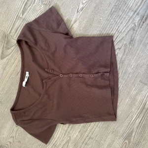 Brun croppad  topp - Croppad kortärmad kofta/tshirt med knappar.