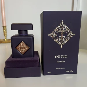 Initio Side Effect Eau de Parfum 90ml - Lyxig parfym från Initio, Side Effect, i en mörklila, matt flaska med guldiga detaljer och fyrkantig form. Flaskan rymmer 90ml och kommer i en elegant ask med sammet och guldfärgat mönster. Perfekt för dig som gillar exklusiva dofter och snygg design. Priset ej hugget i sten vid snabbaffär 
