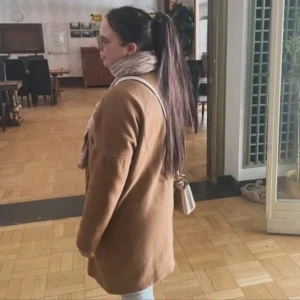 Beige kappa med lång ärm - Säljer en stilren beige kappa med lång ärm och rak passform. Jackan är enkel och tidlös, perfekt för dig som gillar en clean look. Passar snyggt till både jeans och kjol. Fodrad och skön att bära under kyligare dagar.