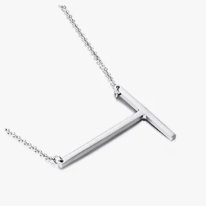 Silverfärgat halsband med T-hänge - Stilrent halsband i silverfärg med ett minimalistiskt T-format hänge. Kedjan är tunn och elegant, perfekt för dig som gillar enkla och moderna smycken. Passar till alla outfits och är lätt att matcha med andra accessoarer.