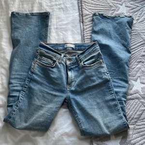 Bootcut Jeans från Gina Tricot - Säljer ett par ljusblå Perfect Jeans från Gina Tricot i klassisk femficksmodell. Jeansen är bootcut, normal passform och är tillverkade i mjukt denimtyg. Snygga detaljer med kontrastsömmar och skinnpatch bak i midjan.