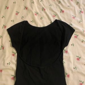 Svart T shirt med öppen rygg från Nelly  - T shirten är helt ny. Lappen är bort klippt och den är från Nelly 
