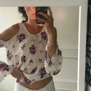 Blommig vit blus med öppna axlar - Superfin blus med blommor. Från Tally Weijl. Aldrig kommit till användning. Frakt ingår i priset 