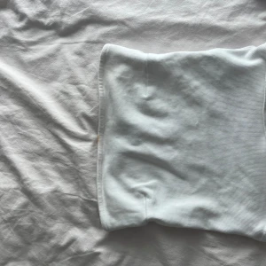 Vit ribbad kortkjol från Gina Tricot - Supersnygg vit ribbad kortkjol från Gina Tricot i stretchigt material. Kjolen har en enkel och clean design som sitter tajt och framhäver figuren. Perfekt att styla med en crop top eller oversized hoodie.