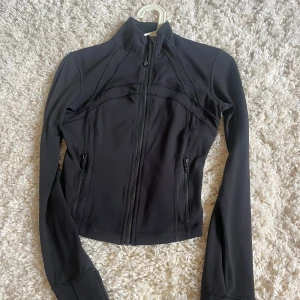 Svart define jacket lululemon  - En snygg define jacka från lululemon. Jackan är helt äkta då jag köpte den själv från lululemon affären i Stockholm. Det är inga fläckar eller liknande på tröjan och den är andvänd några få gånger❤️
