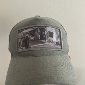 Grå/grön keps från Emilio Pendenza - Snygg grå/grön keps från Emilio Pendenza med mesh på sidorna och baksidan för extra ventilation. Ej använd mycket. Hör av dig om du är intresserad, pris går att diskutera;)