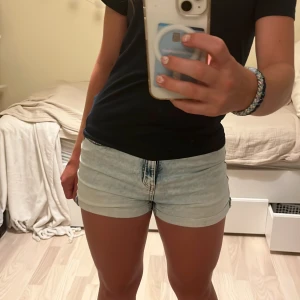 Ljusblå jeansshorts i xs - Snygga ljusblå jeansshorts från Lindex med fickor bak och fram och uppvikta benslut. Medelhög midja. Perfekta för varma sommardagar och lätta att matcha med allt. Lite slitet vid linningen men syns knappt, annars bra skick.