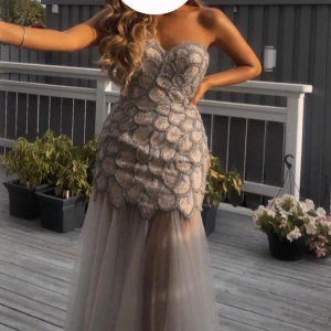 Festlig långklänning med paljetter - Säljer en lyxig klänning från Terani couture. Klänningen är en ärmd i champagnefärg med glittriga paljettdetaljer upptill och en transparent tyllkjol. Perfekt för bal, bröllop eller liknande tillfällen! Den är köpt för 8000 kr men säljer den för 2500 kr pga den är insydd från storlek 36 till 34 använd vid två tillfällen. Skriv privat för frågor och fler bilder. 💕