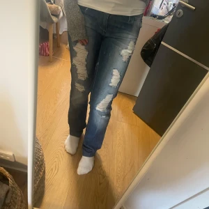 Blå slitna jeans från RL - Snygga blå jeans från RL med slitna detaljer på framsidan.                                   Det är flared/bootcut.                                               Midjematt 39cm, innerbendslängd 88. Perfekta för en trendig/sthlm stil.