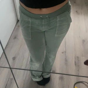Gröna velourbyxor Juicy Couture XS - Snygga ljusgröna mjukisbyxor från Juicy Couture i velour. Byxorna har bred resår i midjan med snörning, stora fickor fram och bakficka med knappdetalj. supermjuk känsla 