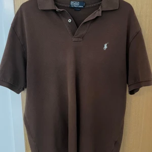 Ralph lauren piké - Ralph lauren pike i brun/beige färg som sticker ut som retro. Storlek L men passar M/L. Använd några gånger så är i bra skick.