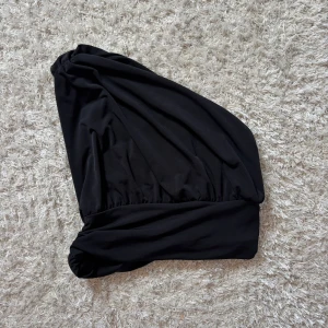 Svart turbanliknande huvudbonad - Säljer en svart turbanliknande huvudbonad i mjukt tyg. Snygg och enkel design med draperad effekt framtill. Perfekt accessoar för att lyfta din look.