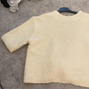 Kvartärmad tröja  - Säljer nu en träning tröja från Lindex. Mysig beige stickad tröja med kortare ärmar.  Den är mjuk och skön att ha på sig och sticks inte, pris kan sänkas vid snabb affär 