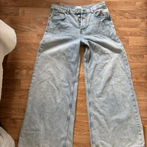 Ljusblå wide leg jeans från Ginatricot  - Säljer ett par ljusblå jeans från Ginatricot med breda ben och medelhög midja. Jeansen har knappar i gylfen och en avslappnad, trendig passform. De är i väldigt fint och bra skick då jag inte använt de så mycket! 😍