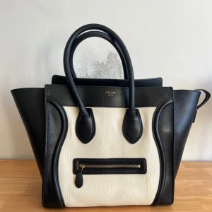 Celine Phoebe Philo era luggage bag - Celine Phoebe Philo era luggage mini bag in creamy white and black leather. The bag has been used, but is well preserved and looks beautiful.  There are natural signs of wear, such as scuffed bottom corners, a few light scratches in the leather and some marks on the inside. Overall, nothing dramatic. Comes with dustbag.  31x31x18