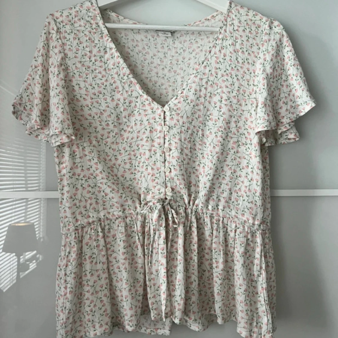 Blommig blus med knyt och volang