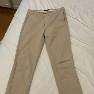 Beige kostymbyxor - Snygga beige kostymbyxor med normal passform och raka ben. Kan bara ta emot swish tyvärr 