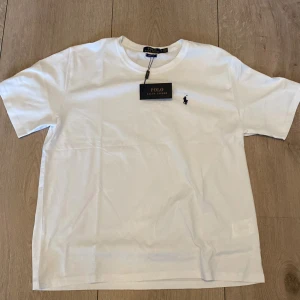 Vit t-shirt från Polo Ralph Lauren - Säljer nu min vita polo Ralph lauren t shirt eftersom den ej kommer till användning och ligger endast i garderoben, tröjan är Aldrgi använd eller tvättad då lappar och tags sitter kvar. Vid fler frågor kontakta mig