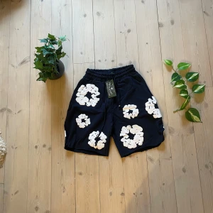 Mörkblåa shorts  från Denim Tears - Mörkblå shorts från Denim Tears. Shortsen har resår i midjan och snörning för extra komfort. Perfekta för en avslappnad och trendig stil.