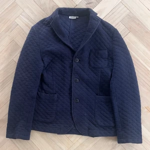 Mörkblå quiltad jacka/kavaj från J.Lindeberg - Snygg mörkblå quiltad jacka från J.Lindeberg i storlek M/175/96A🤌. Går perfekt till vilken skjorta som heller bara en vit tisha under. Bara att höra av sig vid minsta fundering🙌