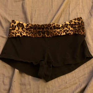Svarta shorts med leopardmönstrad midja från SHEIN - Coola svarta shorts från SHEIN med bred leopardmönstrad linning. Shortsen har en tight passform och är perfekta för dig som vill sticka ut lite extra. Mjukt och stretchigt material som sitter skönt på kroppen. Passar xs/s inte m