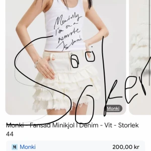 Vit volangkjol i denim från Monki - Supersöt vit minikjol i denim från Monki med flera lager volanger. Kjolen har en kort passform och är perfekt för dig som vill sticka ut med en lekfull och trendig stil. Matcha med en enkel topp för en cool look.