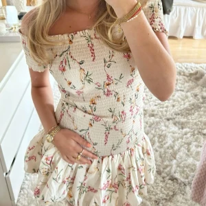 Blommig offshoulder klänning med volang - Söt kortklänning med smockad överdel och volangkjol. Inte mina bilder men är exakt likadan som på bilden, skriv privat för bilder💕💕aldrig använd