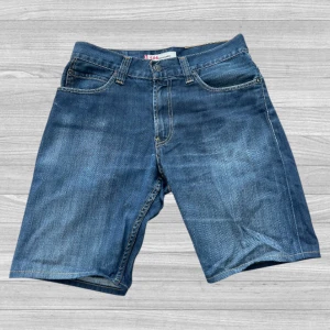 Levi's 506 jeansshorts - Klassiska blå jeansshorts från Levi's modell 506. De har fem fickor, knapp och dragkedja framtill samt bälteshällor. Perfekta för en avslappnad stil under varma dagar.