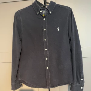 Ralph lauren skjorta 10-12 - Rätt så fint skick. Använd en sommar. Väldigt srechigt och skönt material. Passar runt 146-156 ca. Köpt på åhlsens i stan. Hör av er för mer info 😁