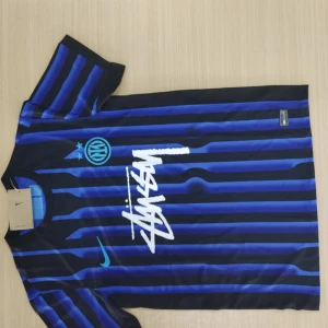 Inter Milan kortärmad fotbollströja - Säljer en blå och svart randig Inter Milan fotbollströja från Nike. Tröjan har korta ärmar, rund hals och klubbens logga samt Nike-logga på bröstet. Snyggt tryck i vitt på framsidan. Perfekt för fans av klubben!