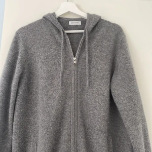 Grå hoodie i kashmir från Soft Goat -  grå hoodie från Soft Goat i mjuk kashmir. Tröjan har använts tre / fyra gånger och är i princip ny.