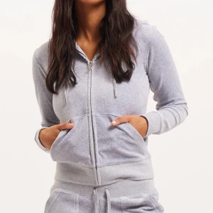 Ljusgrå hoodie med dragkedja - Mysig ljusgrå hoodie med dragkedja och fickor framtill. Tröjan har långa ärmar och en huva med snören. Perfekt för en avslappnad stil. Nypris 1300!