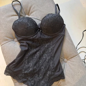 Svart spetsig body - Spetsbody i nyskick från hm, passar storlek xs-m, kupan är 70B, stl 36