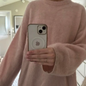 Ljusrosa stickad tröja från H&M - Supermjuk och fluffig ljusrosa stickad tröja från H&M i mohair- och ullblandning. Tröjan har rund halsringning och långa ärmar med avslappnad passform. Perfekt för lager-på-lager och en mysig look.