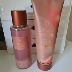 Victoria's Secret Amber Aperitif set - Säljer ett set med Victoria's Secret Amber Aperitif, innehållande en rosa-brons doftmist (250 ml) och en matchande body lotion (236 ml). Doften har inslag av agave nectar och magnolia musk. Snygga flaskor i frostat plast med roséguldsdetaljer. Helt nytt och oanvänt Förhandlar ej med priset