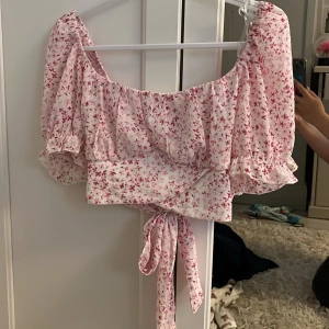 Jättegullig rosa Blommig volangblus💞 - Supersöt blommig blus från New yorker i ljusrosa med små rosa blommor. Toppen har volangdetaljer, puffiga korta ärmar och knytband både fram och bak. Perfekt för en somrig look, endast testad!🌸🌷