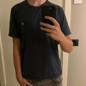 Stone Island T-shirt  - Stone Island T-shirt i storlek 170 14y den är i bra skick då den tyvärr har ett litet hål.