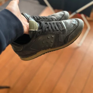 Svarta Valentino Rockrunner sneakers - Säljer ett par svarta Valentino Rockrunner sneakers med coola nitar på sidorna. Det är en del nitar som lossnat, det är i okej bra skick. Tillverkade i en mix av skinn och mocka.                      Bara skriva vid funderarsr. Pris ej hugget i sten! MVH  