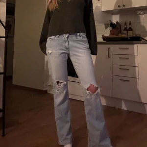 Ljusblå slitna jeans från Lee - Ljusblå jeans från Lee med raka ben och snygga slitningar på båda knäna. Jeansen har klassisk femficksdesign, normal passform och dragkedja i gylfen. Perfekta för en avslappnad och trendig look.