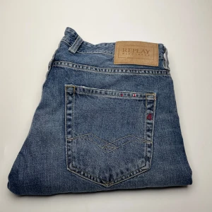 Replay jeans  - Snygga Replay Grover jeans i klassisk blå denim med raka ben och normal passform. Jeansen har tydliga sömmar, bakficka med broderad detalj och läderpatch med Replay-logga i midjan. Perfekta för dig som gillar stilrena och tidlösa jeans.