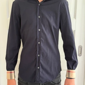 Burberry skjorta - Mörkblå Burberry skjorta i storlek S, modellen är ca 184 och bär M i vanliga fall, skjortan passar mellan 170-180! Köpt på plick, bra skick! Pris-799kr