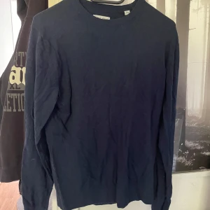 Mörkblå långärmad tröja Jack & Jones - En stilren mörkblå långärmad tröja från Jack & Jones. Tröjan har rund halsringning och är tillverkad i mjuk bomull, perfekt för lager-på-lager. Enkel design utan mönster eller detaljer, passar dig som gillar en clean look. Perfekt o ha över skjortan 