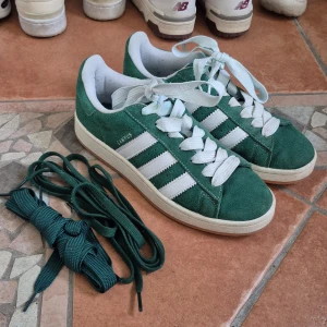 Adidas Campus - Gröna Adidas Campus sneakers i mocka. Ganska bra skick förutom lite smuts på sulorna samt en fläck som syns i bild 4. De vita skosnörena är lite missfärgade från skon men två par gröna skosnören medföljer. Pris kan absolut diskuteras.